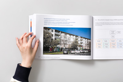 Page 42–43,  Health literacy in social housing (Resident Voice Report). Iage showing a page spread with an exterior photograph of social housing in South Melbourne, taken by Nikki M Group.